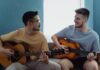 Proste duety na dwie gitary i głos, idealne do wspólnego śpiewania ze znajomymi Dwóch mężczyzn gra razem na gitarach akustycznych w jasnym salonie