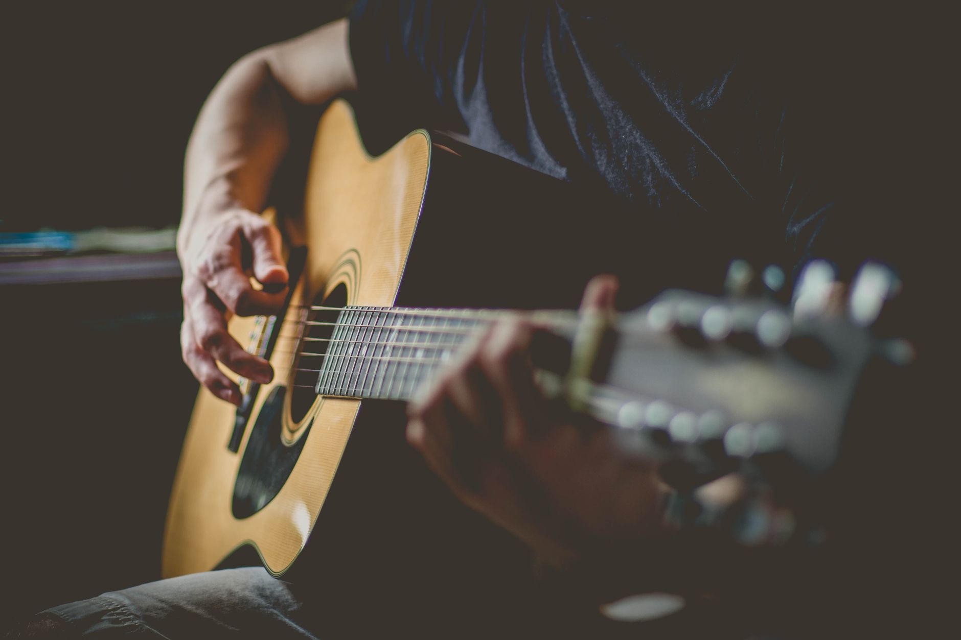 Zbliżenie dłoni grających proste akordy na gitarze akustycznej